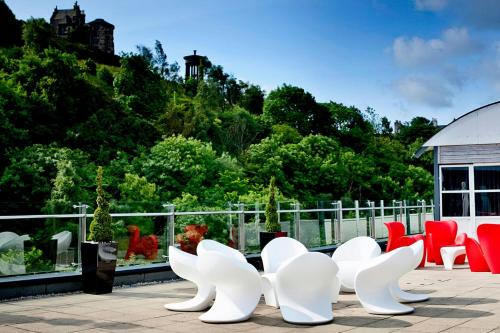 a row of white chairs sitting on a patio at The Glasshouse, Autograph Collection in Edinburgh