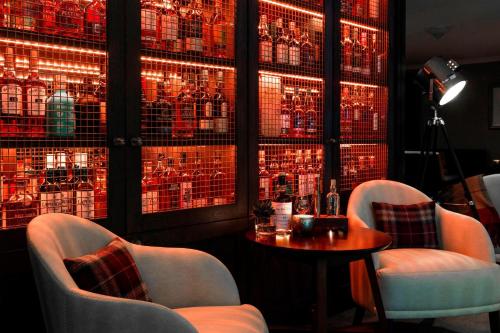 a room with two chairs and a table and red lights at The Glasshouse, Autograph Collection in Edinburgh