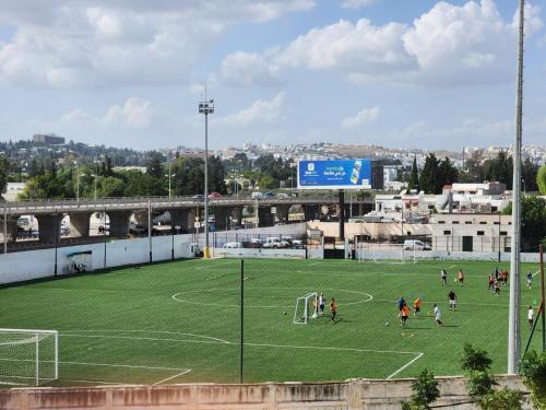 a group of people playing soccer on a soccer field at Ayoub Jus Station métro de Cité el Khadra in Tunis