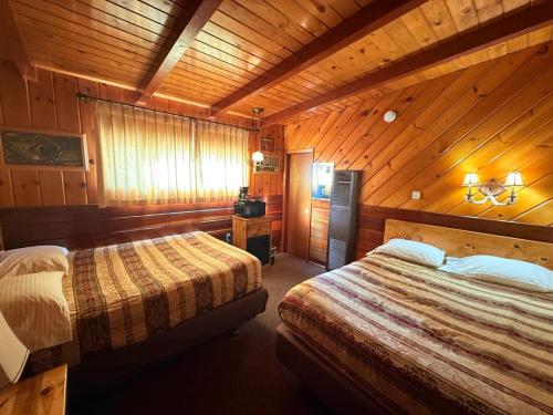 a bedroom with two beds in a wooden cabin at Toiyabe Motel in Walker