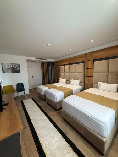 a hotel room with two beds and a television at Hilal Palace - Halal in Golem