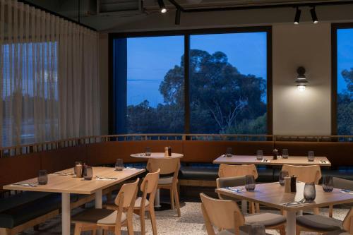 a restaurant with tables and chairs and large windows at Courtyard by Marriott Perth Murdoch in Fremantle
