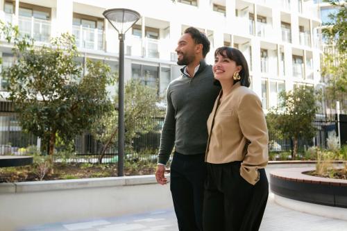 a man and a woman standing in front of a building at Courtyard by Marriott Perth Murdoch in Fremantle