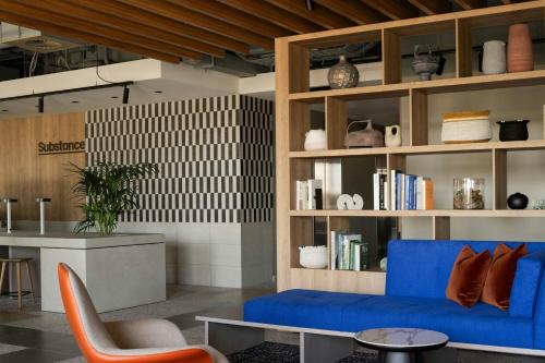 a living room with a blue couch and bookshelves at Courtyard by Marriott Perth Murdoch in Fremantle