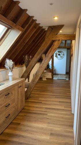 une chambre mansardée avec poutres en bois et parquet dans l'établissement Au relais des diligences, à Mézières-en-Vexin
