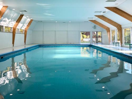an indoor swimming pool with blue water at Cosy Cabin Durbuy in Durbuy