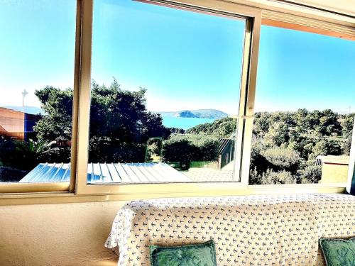 a room with a couch and a large window at Villa Mare Azzurro, 2 passi dal mare in Simius