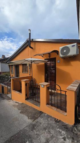 an orange building with an umbrella and a building at Il Richiamo della Cascata in Papigno