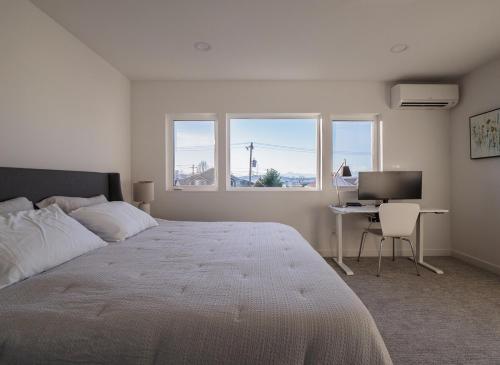 a bedroom with a bed and a desk with a computer at Steps to Alki Beach with Water Views Rooftop deck in Seattle