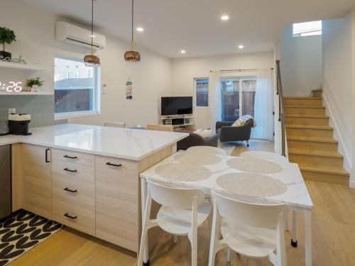 a kitchen with a table and chairs and a living room at Steps to Alki Beach with Water Views Rooftop deck in Seattle