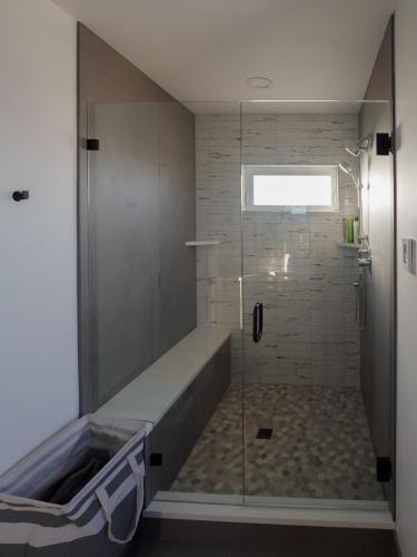 a bathroom with a shower with a glass door at Steps to Alki Beach with Water Views Rooftop deck in Seattle