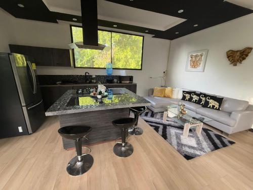 a kitchen and living room with a couch and a table at Wahi Maluhia in Cahuita