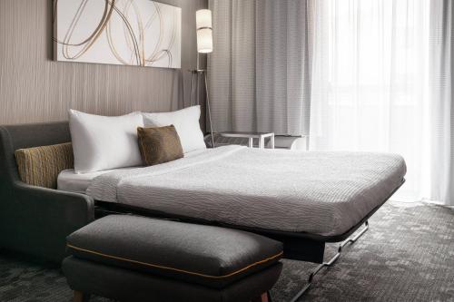 a hotel room with a bed and a chair at Courtyard by Marriott Boulder in Boulder