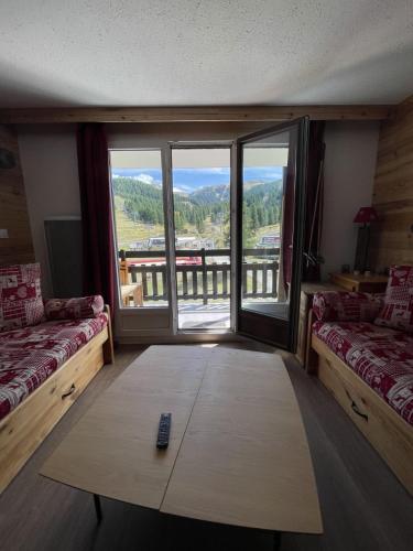 Cette chambre dispose d'un canapé, d'une table basse et d'une fenêtre. dans l'établissement Superbe appartement 5 à 6 couchages front de neige Risoul, à Risoul