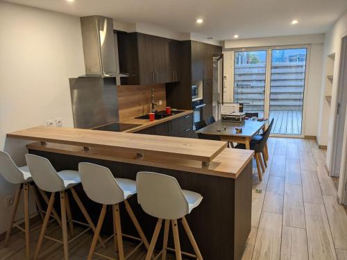 une cuisine avec un grand îlot et des tabourets de bar dans l'établissement Séjour nature à St Lyphard maison tout équipée, à Saint-Lyphard