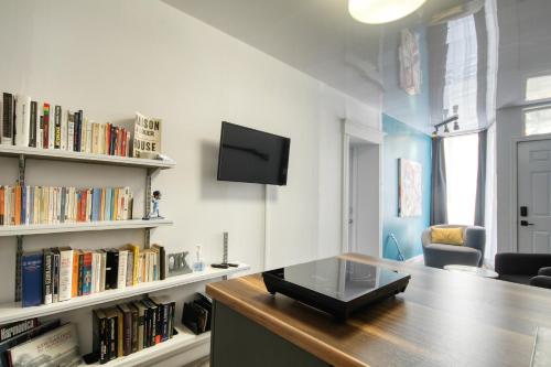 a room with a desk with a tv and books at Place des Arts by Hébergements DCL in Quebec City