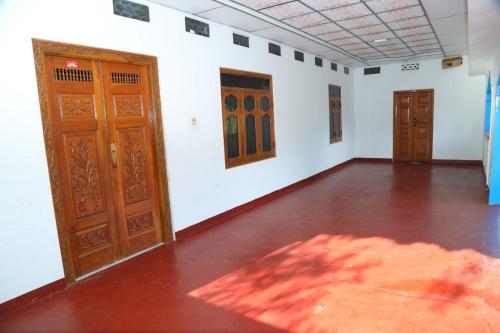 an empty room with wooden doors and a floor at Flamingo Resort in Mannar