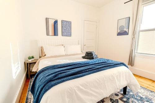 a bedroom with a bed with a blue blanket on it at Harvard 3BDR- 5 Min Walk to Davis Sq - Free Parking in Somerville