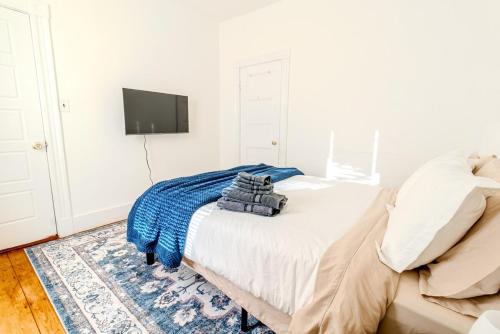 a bedroom with a bed and a tv on a wall at Harvard 3BDR- 5 Min Walk to Davis Sq - Free Parking in Somerville