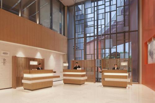 a lobby with people sitting at reception desks at Courtyard by Marriott Hangzhou Xihu in Hangzhou