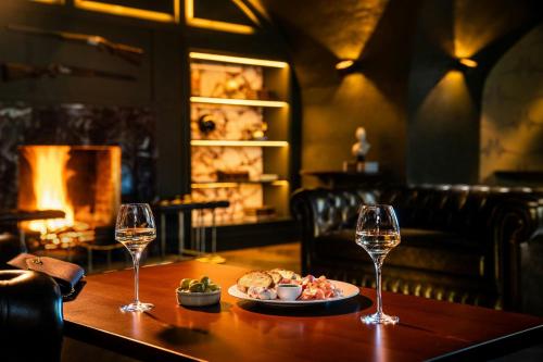 a table with a plate of food and two wine glasses at Mount Juliet Estate, Autograph Collection in Thomastown