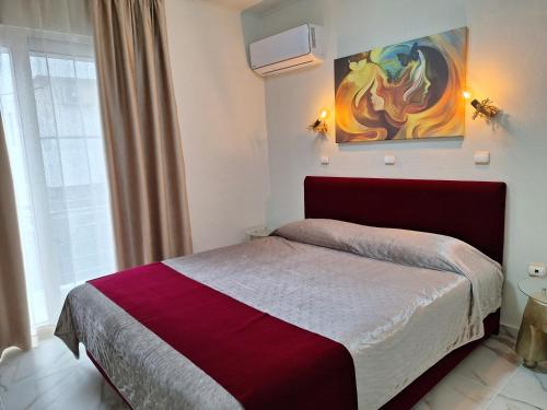 a bedroom with a bed and a painting on the wall at Modern Quiet Apartment in the Center of Rhodes in Rhodes Town