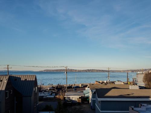 a view of a body of water with houses and buildings at Steps to Alki Beach with Water Views Rooftop deck in Seattle
