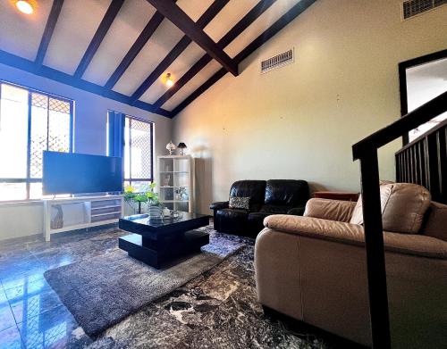 a living room with a couch and a flat screen tv at Affotable Relocation FIFO Long Term Queen Bedroom Near City Fremantle Sawn River in Perth