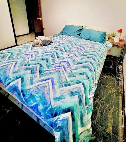 a bed with a colorful comforter on top of it at Affotable Relocation FIFO Long Term Queen Bedroom Near City Fremantle Sawn River in Perth