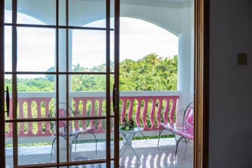 a view of a balcony with a table and chairs at Sweetsop Jamaica Villa and Tour in Montego Bay
