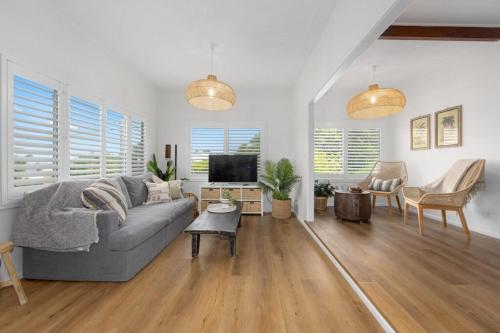a living room with a couch and a tv at Bonny Chill - Walk to beaches, pet friendly in Bonny Hills