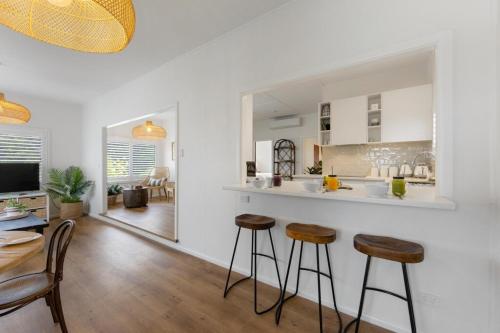 a kitchen with a counter and stools in a room at Bonny Chill - Walk to beaches, pet friendly in Bonny Hills