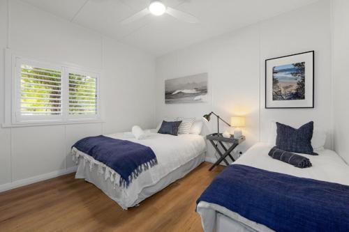 a white bedroom with two beds and a window at Bonny Chill - Walk to beaches, pet friendly in Bonny Hills