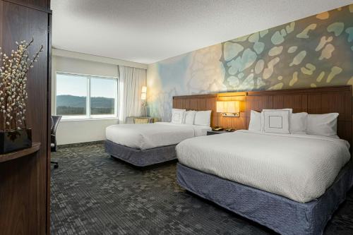 a hotel room with two beds and a painting on the wall at Courtyard by Marriott Asheville Airport in Arden