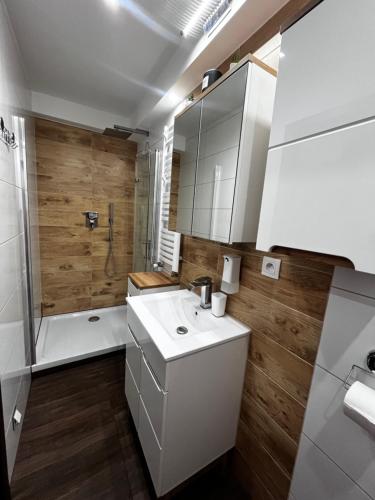 Un baño con lavabo blanco y ducha. en Apartament Crooked stairs, en Zielona Góra