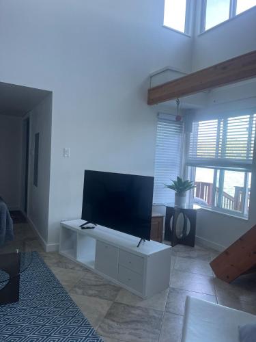 a living room with a flat screen tv on a white cabinet at Lakefront retreat close to Microsoft and Bellevue in Redmond