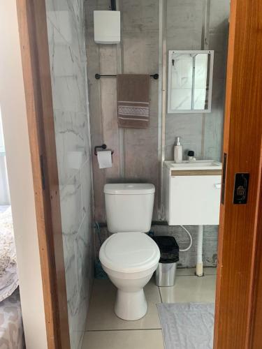 a bathroom with a white toilet and a sink at Vila do Chaves Casa da Popis 23 in Itajaí