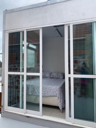 a room with sliding glass doors and a bed at Vila do Chaves Casa da Popis 23 in Itajaí