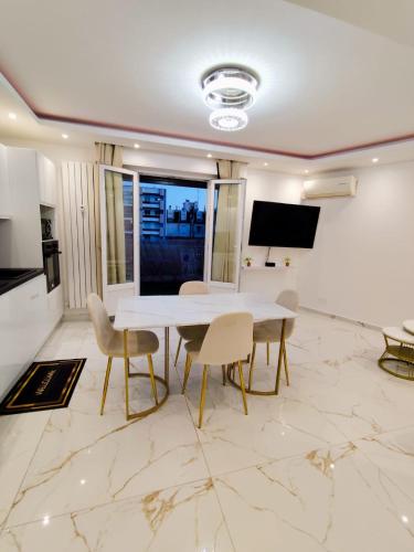 une salle à manger avec une table et des chaises blanches dans l'établissement Cozy appartment downtown Nizza 2 Bedroom 1 min Beach 1 min tramway 10min airport air conditionner, à Nice