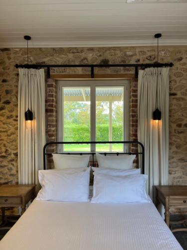 a bedroom with a bed with white pillows and a window at Oxenberry Farm in McLaren Vale