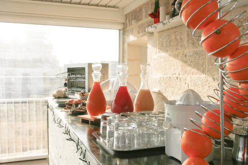 Sui Tetti Luxury Rooms في ليتشي: منضدة المطبخ عليها مزهريات حمراء