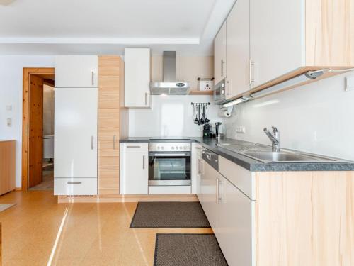 a kitchen with white cabinets and a sink at Elisabeth Sonnenseite in Mittersill