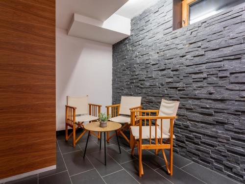 a room with a table and chairs and a brick wall at Jäger in Maria Alm am Steinernen Meer
