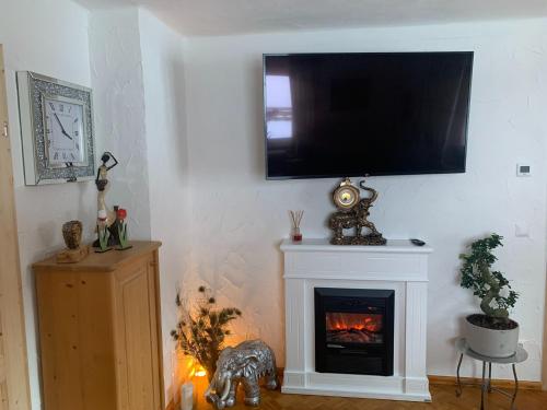 a living room with a fireplace with a flat screen tv on the wall at Holiday Home Muhr near Ski Slopes in Muhr