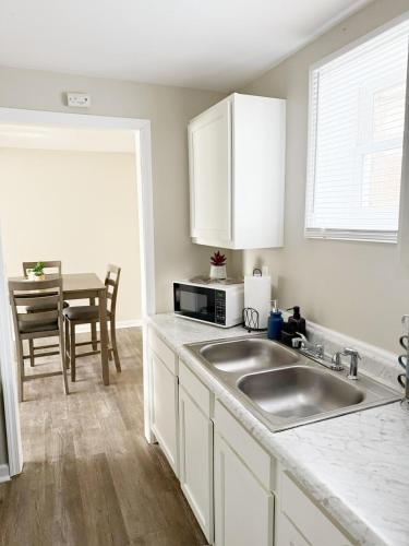 a white kitchen with a sink and a table at Riverside Retreat Apartments in Evansville