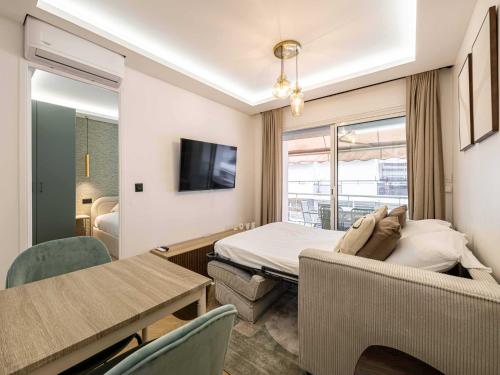 une chambre d'hôtel avec un lit, une table et des chaises dans l'établissement Elegant Apt with balcony 1BD 4P - Croisette Cannes, à Cannes