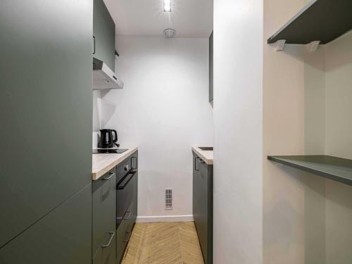 - une cuisine avec des murs blancs et des placards gris dans l'établissement Elegant Apt with balcony 1BD 4P - Croisette Cannes, à Cannes