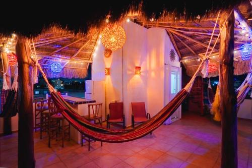 a hammock in a room with chairs and a bar at Tranquility House Cancun in Cancún