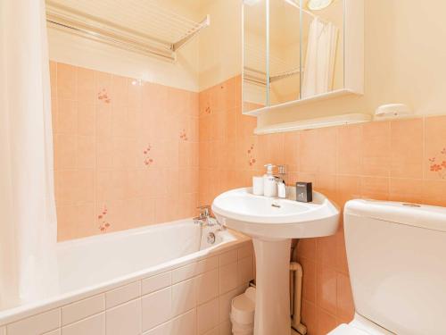 une salle de bain avec un lavabo, des toilettes et une baignoire dans l'établissement Modern Apartment with Terrace Trouville, à Trouville-sur-Mer