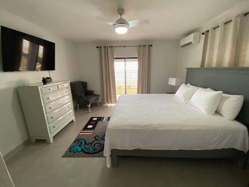 Un dormitorio con una cama blanca y una cómoda. en Landing Strip, en Black River